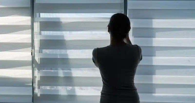 roló ablakra - fiatal nő egy résreluxát állít be