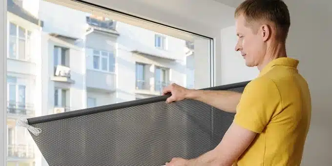 szürke vászonroló szerel fel egy férfi